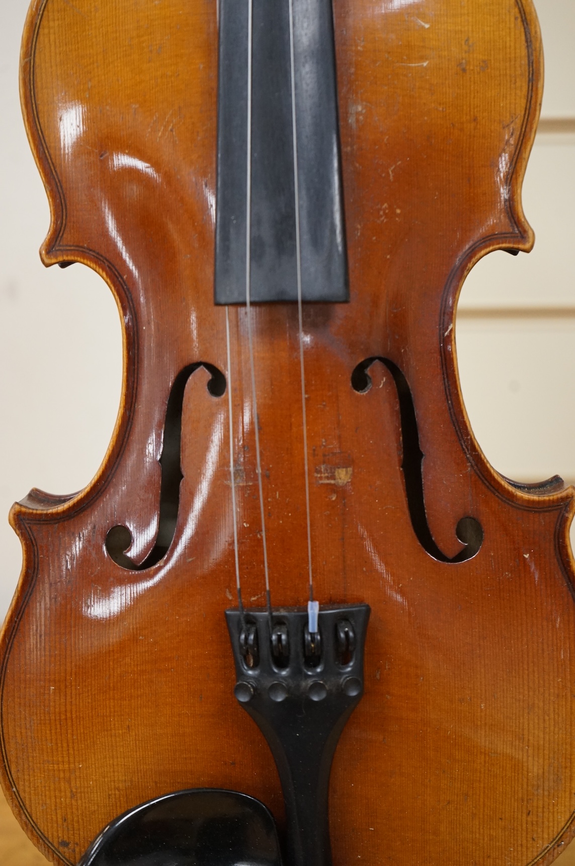 Five cased 20th century violins, including; a German violin, two Czech violins, a three-quarter size violin with a label for Bienfait, and a Romanian quarter size violin, all in cases or the remains of cases.